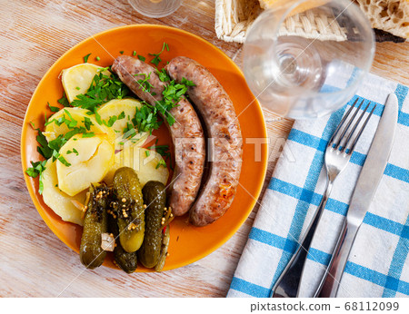 Grilled sausages with boiled potato and gherkins 68112099