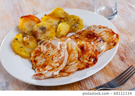 Appetizing fried pork with potatoes and herbs Appetizing fried pork with potatoes and herbs 68112134