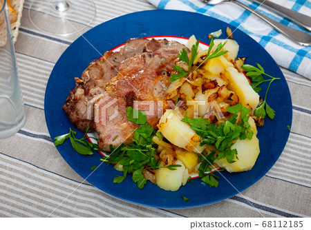 Served dish with fried pork, herbs and potatoes Served dish with fried pork, herbs and potatoes 68112185