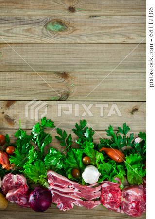Raw mutton and vegetables assortment on natural wooden background Raw mutton and vegetables assortment on natural wooden background 68112186