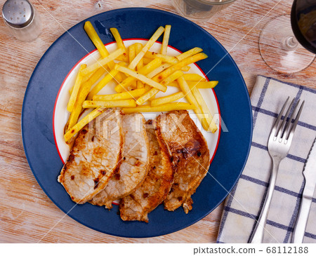 Roasted steaks of pork loin with French fried potatoes Roasted steaks of pork loin with French fried potatoes 68112188