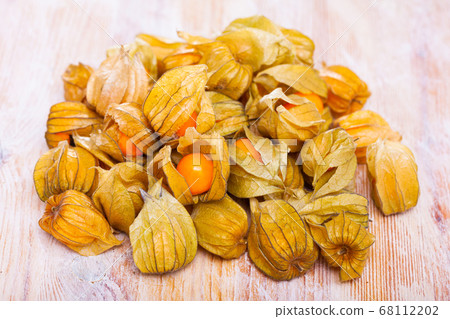 Closeup of yellow ripe physalis fruit (Physalis peruviana) on wooden table. Fruits and vegetables; vegetarian and healthy eating Closeup of yellow ripe physalis fruit (Physalis peruviana) on wooden table. Fruits and vegetables; vegetarian and healthy eating 68112202