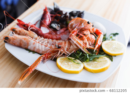Plate with cooked shrimps, langoustines, clams Plate with cooked shrimps, langoustines, clams 68112205
