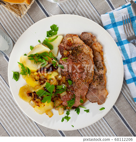 Appetizing fried pork with potatoes and herbs Appetizing fried pork with potatoes and herbs 68112206