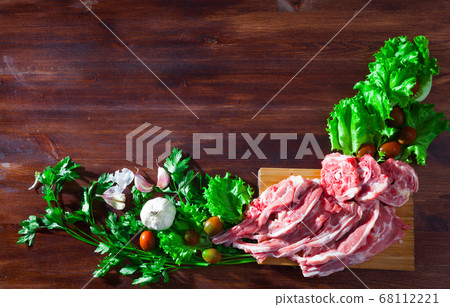 Wooden background with raw lamb, vegetables, greens Wooden background with raw lamb, vegetables, greens 68112221
