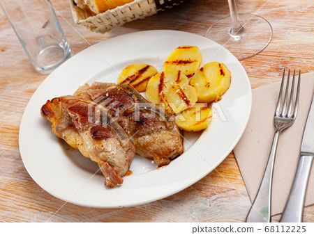 Fried pork on bone with grilled potatoes Fried pork on bone with grilled potatoes 68112225