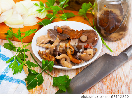 Various canned mushrooms, onions and greens on wooden table 68112260