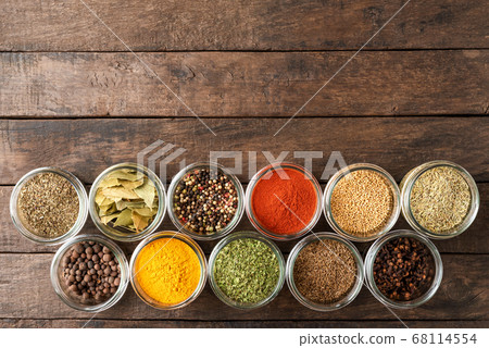 Colourful spices in bowls on wooden table with copyspace. Big collection of spices. Top view 68114554