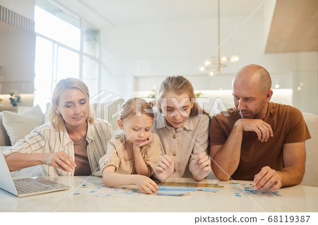 Family Solving Jigsaw Puzzle Family Solving Jigsaw Puzzle 68119387