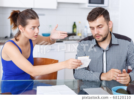 Upset young couple with financial bills having conflict in home Upset young couple with financial bills having conflict in home 68120110