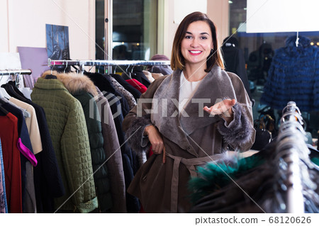Girl choosing sheepskin coat Girl choosing sheepskin coat 68120626