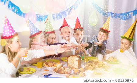 Smiling children enjoying friend’s festive dinner 68120976