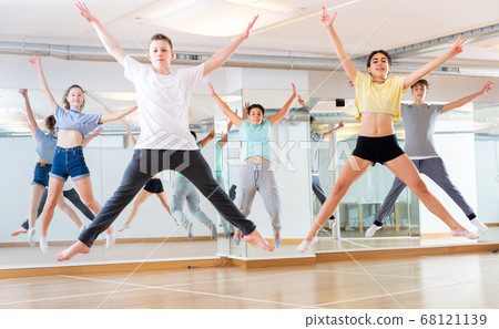 Group of young dancers jumping together in class Group of young dancers jumping together in class 68121139