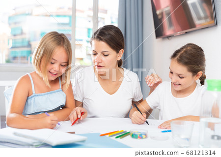 Young woman and two daughters drawing together Young woman and two daughters drawing together 68121314