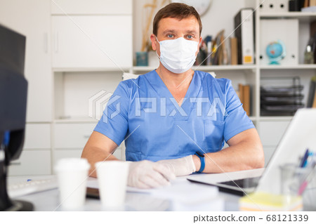 General practitioner listening to patient in office 68121339