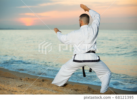 Joyful man doing karate at ocean quay Joyful man doing karate at ocean quay 68121395