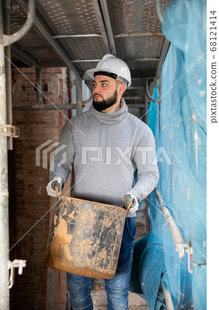 Contractor carrying bucket with cement mortar 68121414