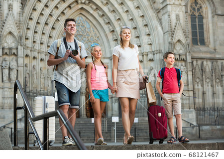 Young family travelers walking in city with baggage Young family travelers walking in city with baggage 68121467