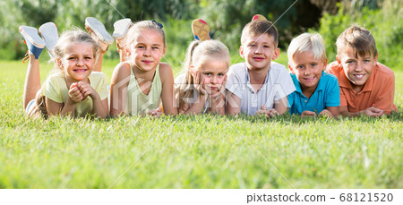 kids lying on green grass kids lying on green grass 68121520