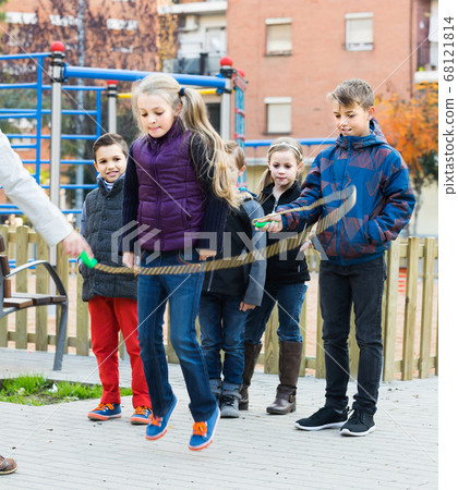 Children playing rubber band jumping game and laughing 68121814