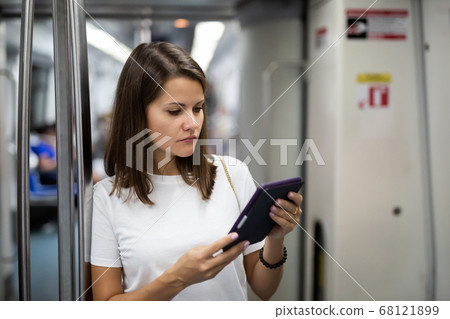 Woman using tablet in subway car Woman using tablet in subway car 68121899