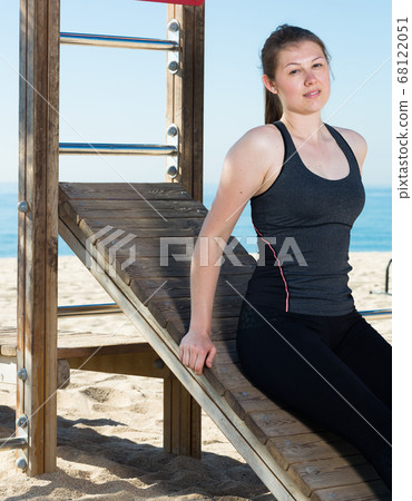 Woman posing during training on beach Woman posing during training on beach 68122051
