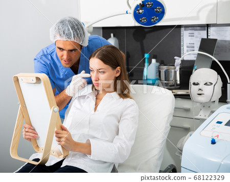 Man cosmetologist giving consultation to woman client 68122329