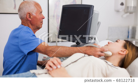 Elderly male sonographer examining woman Elderly male sonographer examining woman 68122718