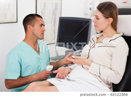 Doctor talking with woman before examination with ultrasound Doctor talking with woman before examination with ultrasound 68122866