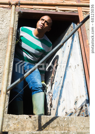 Portrait of man at doorway of building 68123036