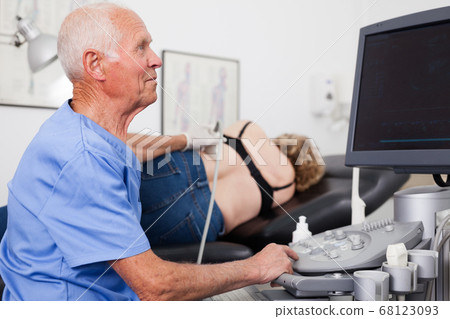 Doctor with ultrasonography device during examines woman at kidneys 68123093