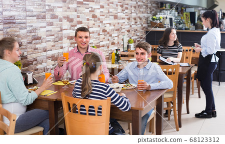 family with teenage children enjoying meal in cafe family with teenage children enjoying meal in cafe 68123312