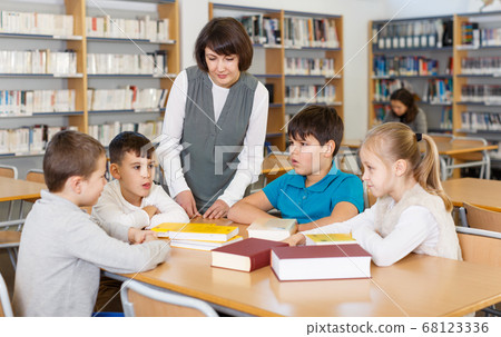 School kids studying with female teacher School kids studying with female teacher 68123336