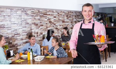 Waiter serving mother with two children Waiter serving mother with two children 68123361