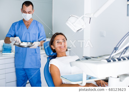 Client woman is sitting satisfied after treatment in dental clinic 68123623