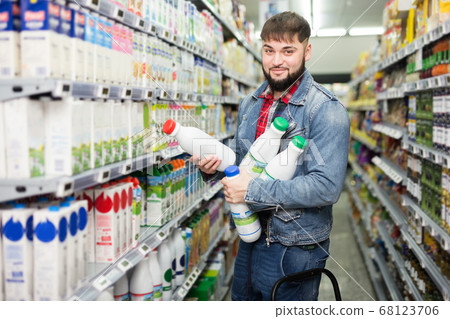 Man choosing dairy products in grocery Man choosing dairy products in grocery 68123706