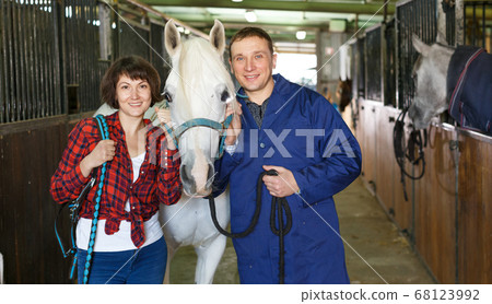 Man and woman at horse stable Man and woman at horse stable 68123992