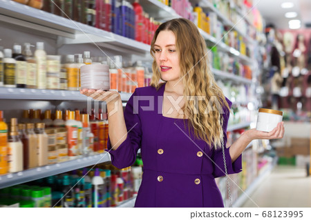 Modern glad woman holding hair care purchased Modern glad woman holding hair care purchased 68123995