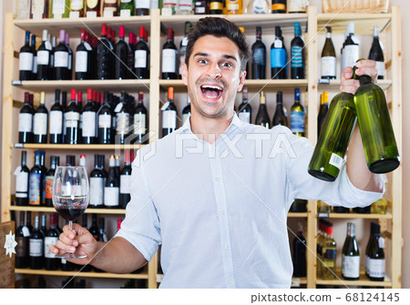 Man holding glass and bottle in winery section Man holding glass and bottle in winery section 68124145