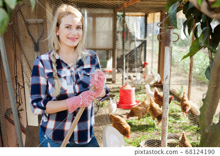 Young woman farmer caring for poultry Young woman farmer caring for poultry 68124190