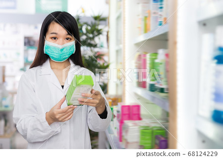 Female chinese pharmacist posing in pharmacy 68124229