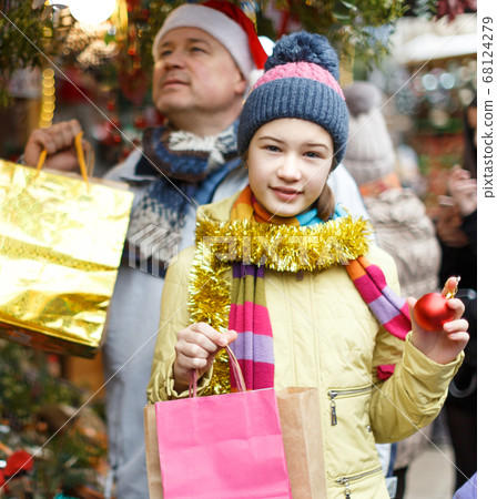 Smiling girl after Christmas shopping with father Smiling girl after Christmas shopping with father 68124279