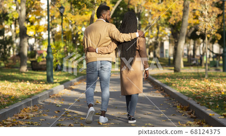 Rear view of couple in love walking in autumn park 68124375