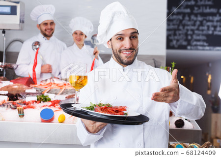 chef with dishes on serving tray welcoming 68124409