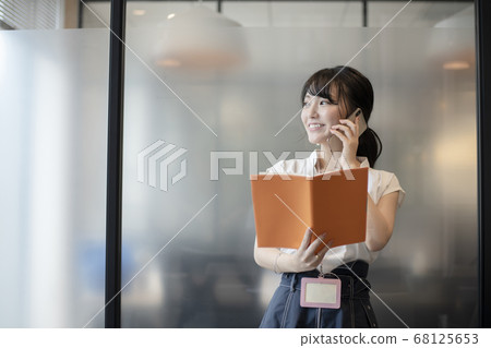 A woman who checks a schedule by telephone 68125653