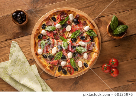 Pizza and few ingredients on wooden background 68125976