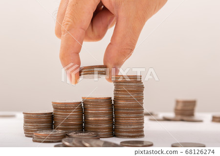 Hand putting coins on stack on table,Saving money 68126274