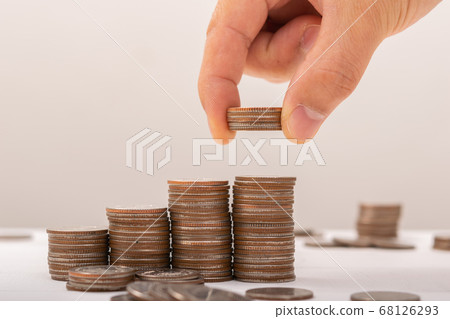 Hand putting coins on stack on table,Saving money 68126293