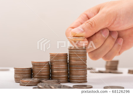 Hand putting coins on stack on table,Saving money 68126296