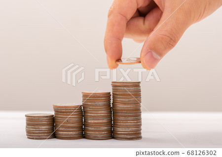 Hand putting coins on stack on table,Saving money 68126302